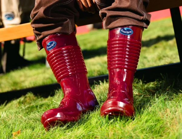 Glossy red Ocean Spray Jellied Bog Boots photographed on grass